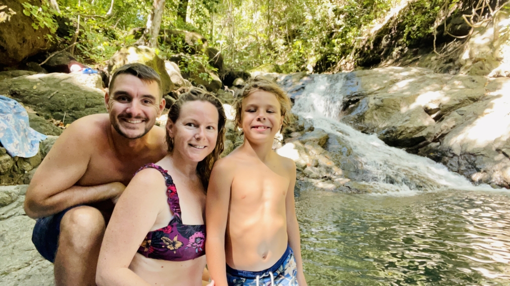 Family in front of small waterfall costa rica